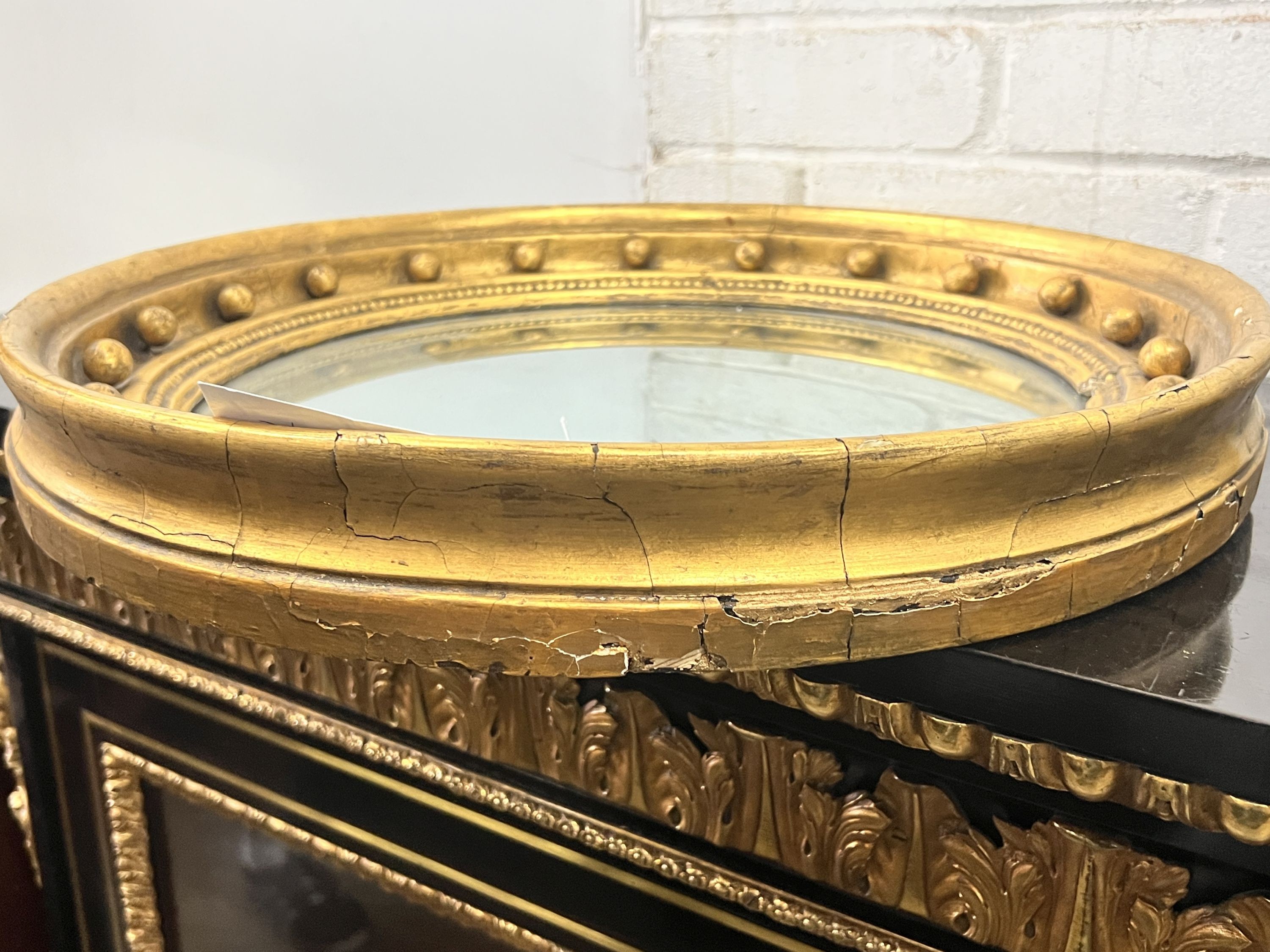 A Regency mahogany circular gilt framed convex wall mirror, diameter 49cm